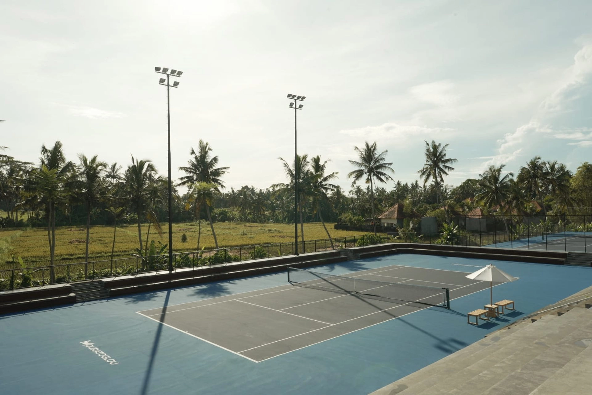 Outdoor tennis court surrounded by tropical landscape at Mouratoglou Tennis Center Bali.