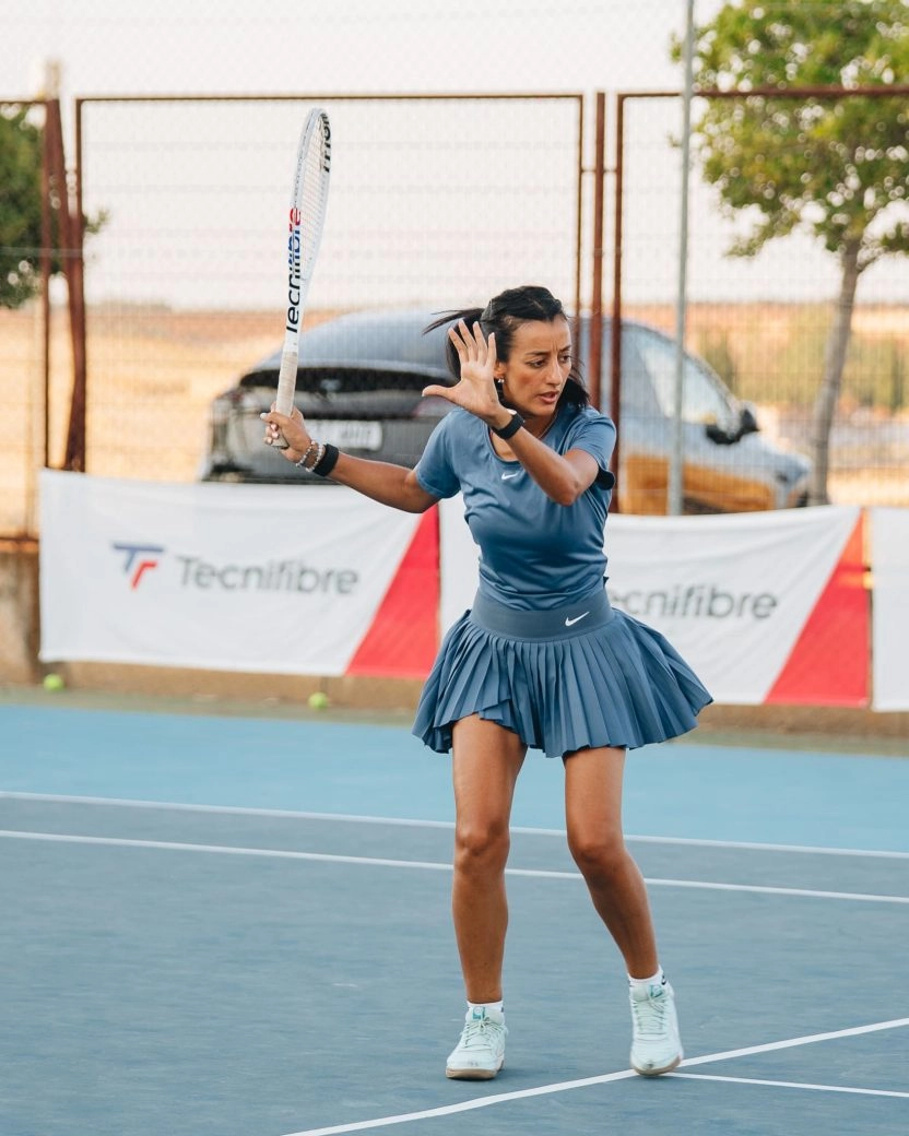 Woman hitting a tennis shot on an outdoor court at Mouratoglou Tennis Center Calatrava.
