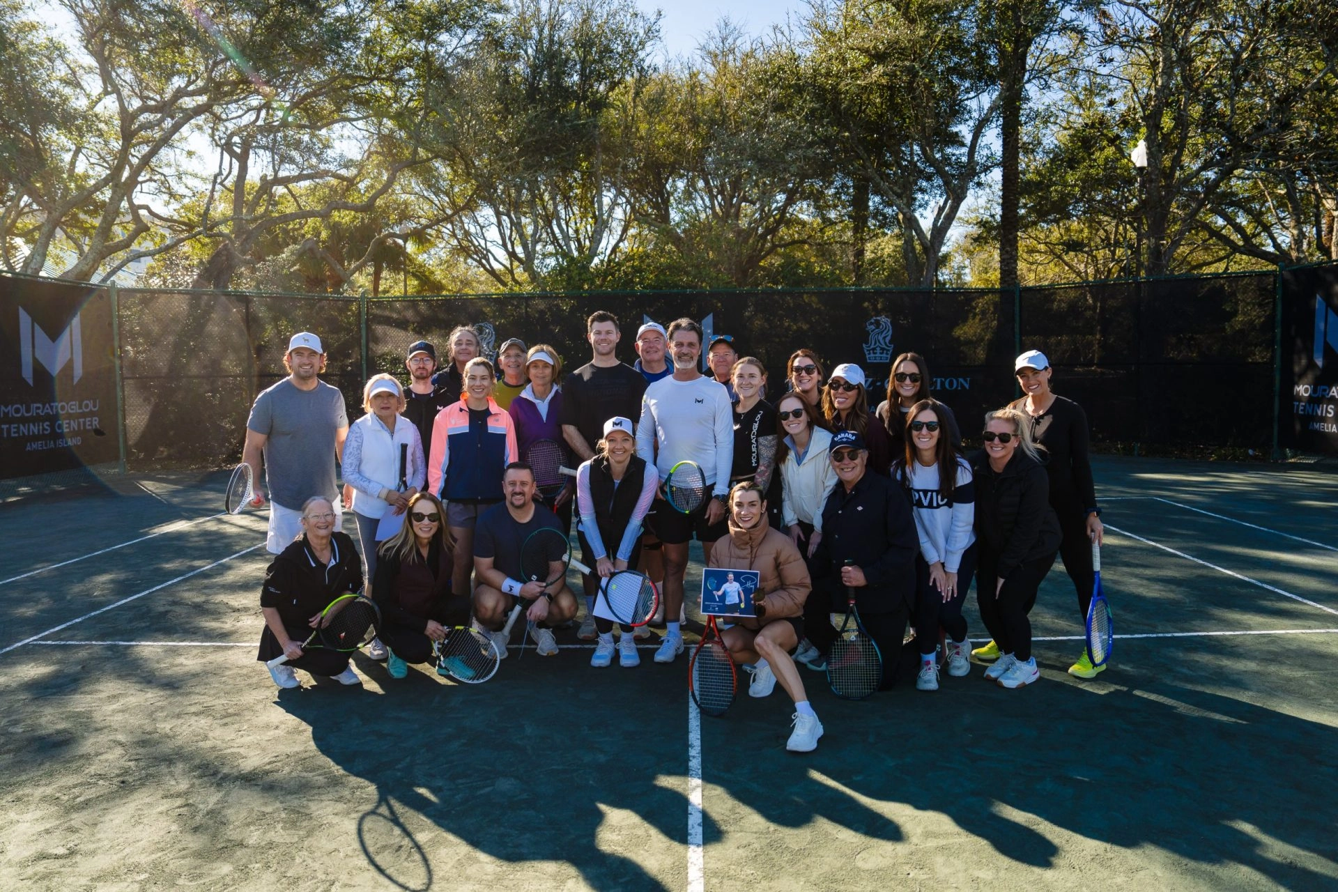 Group of adult players posing with Patrick Mouratoglou at Mouratoglou Tennis Center Amelia Island.