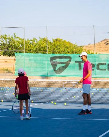 Tennis coach and player training on a blue hard court at Mouratoglou Tennis Center Calatrava