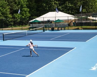 Adult tennis player training on court at Mouratoglou Tennis Center Boston, Massachusetts