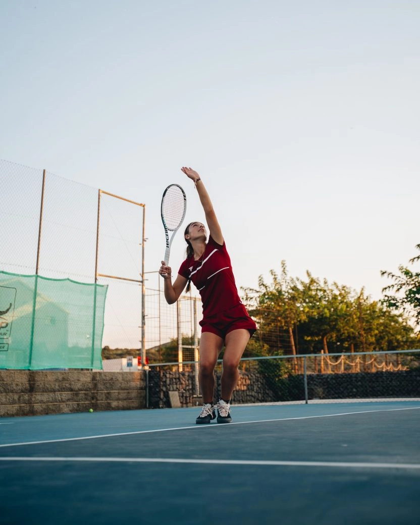 Female tennis player serving at Mouratoglou Tennis Center Calatrava with modern court architecture