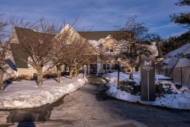 Exterior view of Mouratoglou Tennis Center Boston with branded totem in the snow, Massachusetts