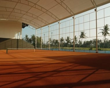 Semi-indoor clay tennis court at Mouratoglou Tennis Center Bali surrounded by tropical scenery
