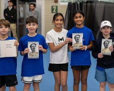 Junior tennis players posing with Patrick Mouratoglou’s book at Mouratoglou Tennis Center Boston