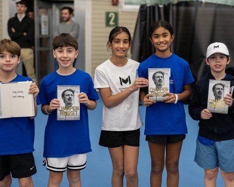 Junior tennis players posing with Patrick Mouratoglou’s book at Mouratoglou Tennis Center Boston