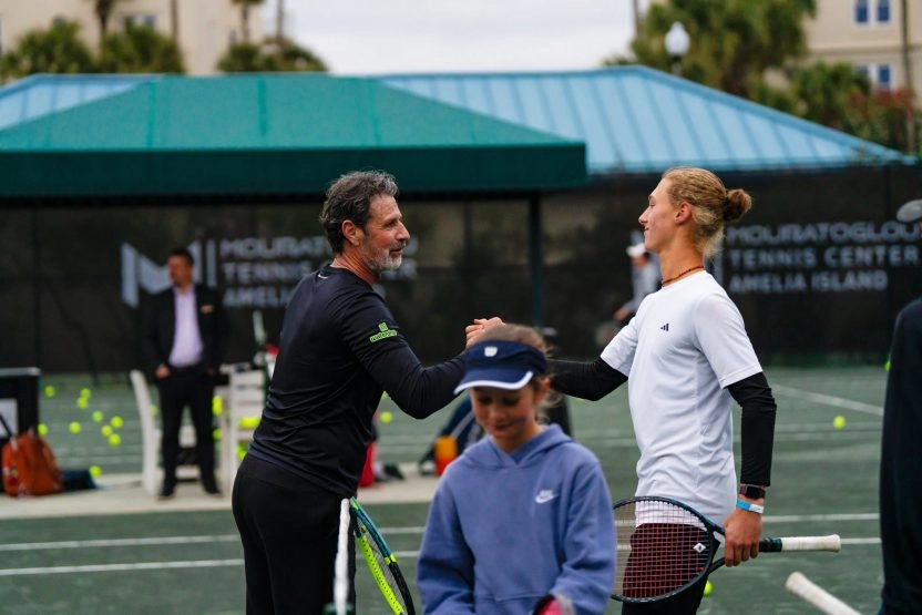 Patrick Mouratoglou giving a fist bump to a junior program player at Mouratoglou Tennis Center Amelia Island.