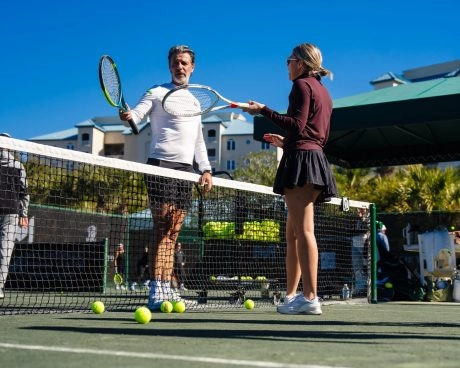 Patrick Mouratoglou coaching a female player on court at Mouratoglou Tennis Center Amelia Island.