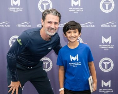 Patrick Mouratoglou posing with a junior player at Mouratoglou Tennis Center Boston, Massachusetts