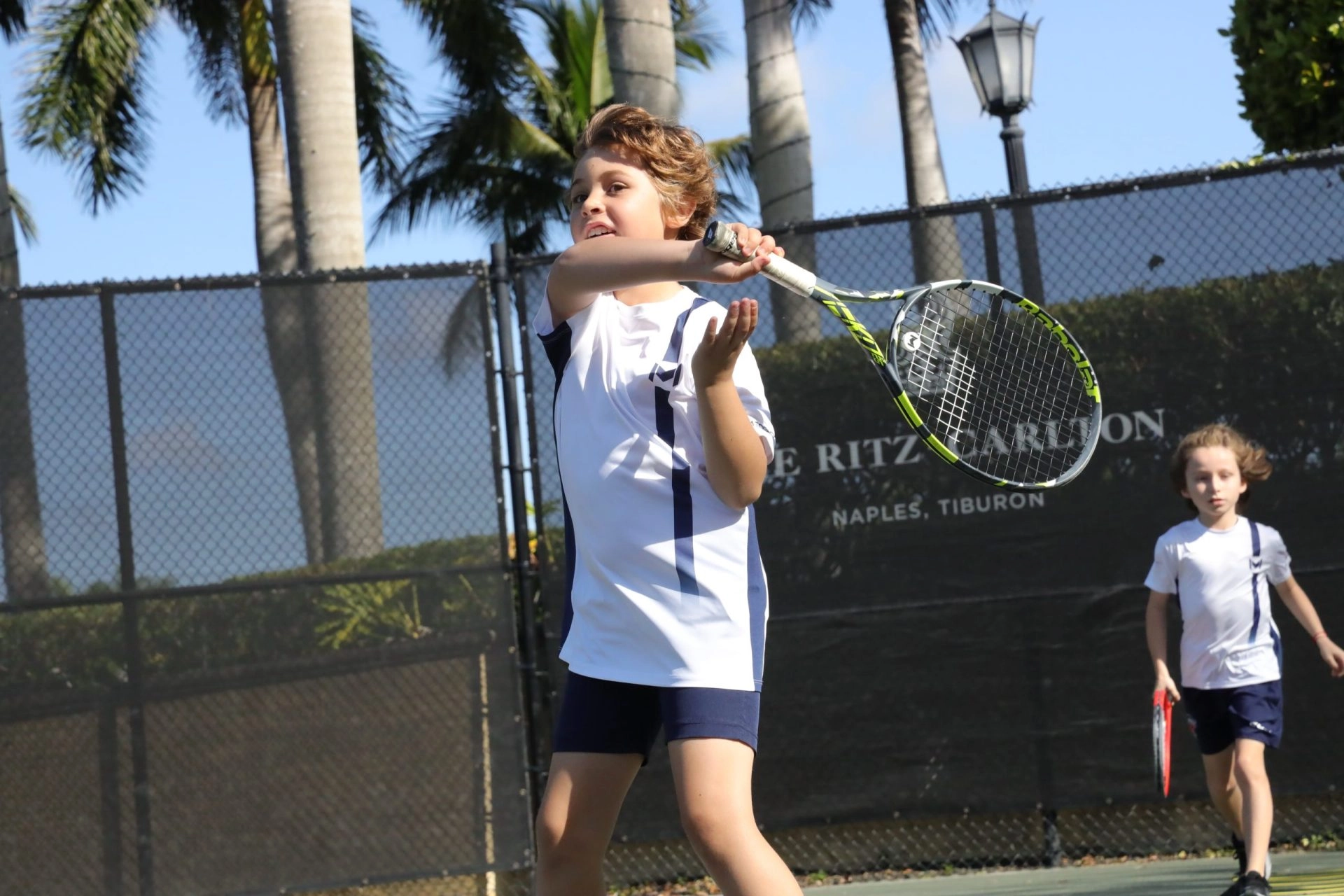 Young tennis player practicing on court during a training session at Mouratoglou Tennis Center Naples at The Ritz-Carlton Naples, Tiburón.