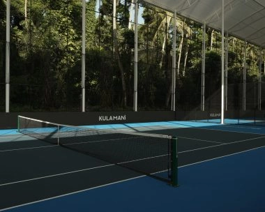 Covered hard tennis court at Mouratoglou Tennis Center Bali with roof structure and tropical foliage in the background.
