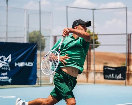 Adult tennis player executing a forehand on an outdoor court at Mouratoglou Tennis Center Calatrava.