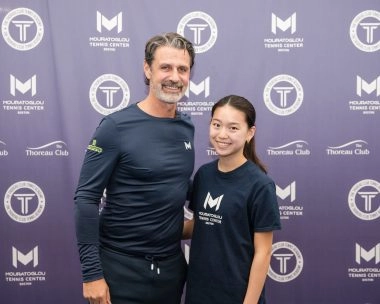 Patrick Mouratoglou smiling with a young player at Mouratoglou Tennis Center Boston