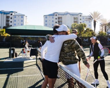 Patrick Mouratoglou greeting a player on the tennis courts at Mouratoglou Tennis Center Amelia Island.