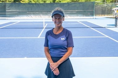 Tennis coach posing on court at Mouratoglou Tennis Center Boston