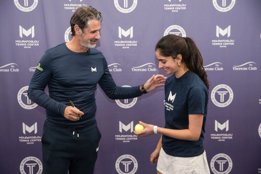 Patrick Mouratoglou signing tennis ball at Mouratoglou Tennis Center Boston