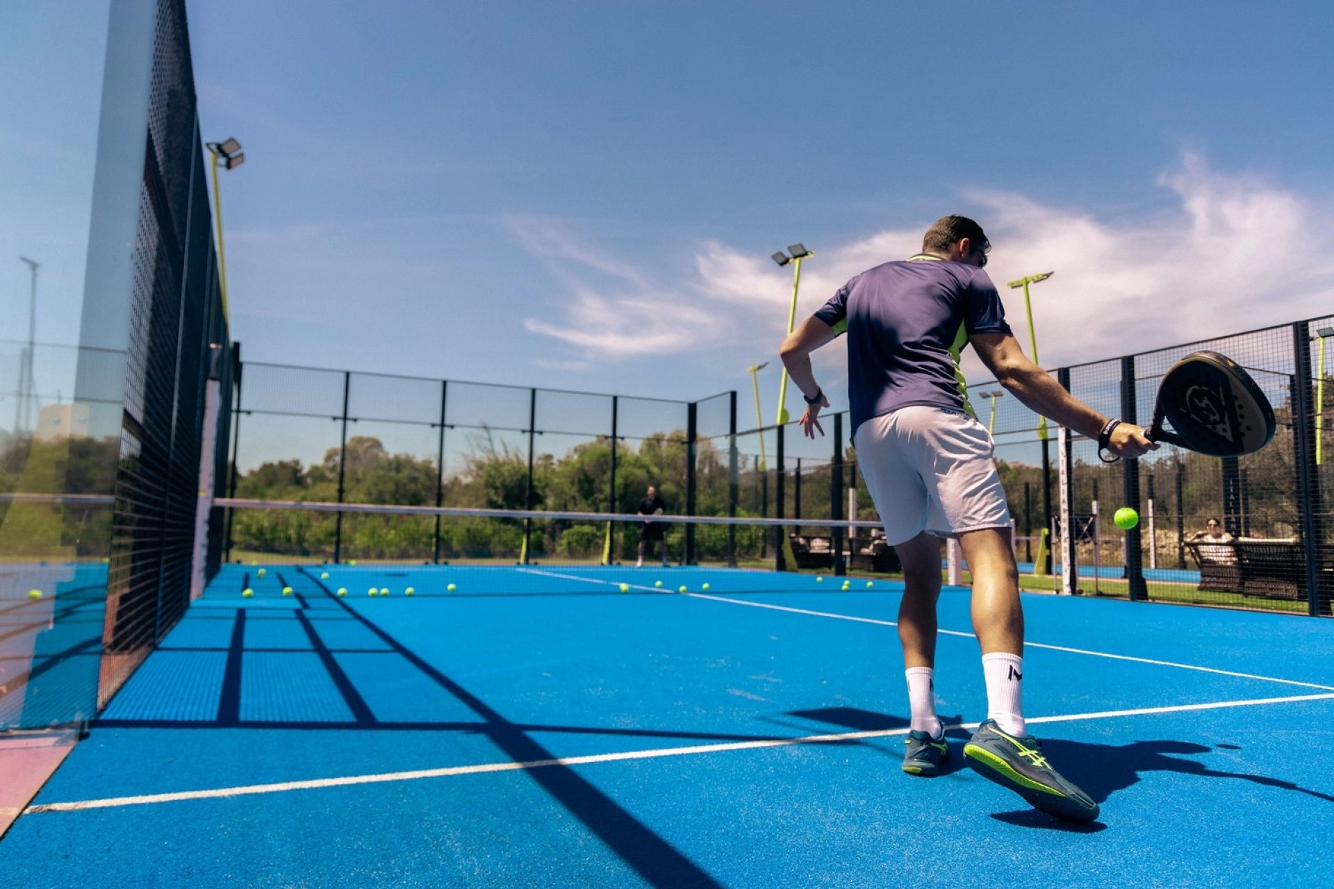 Player hitting a padel shot at Mouratoglou Tennis Center Cala di Volpe in Costa Smeralda, Sardinia.