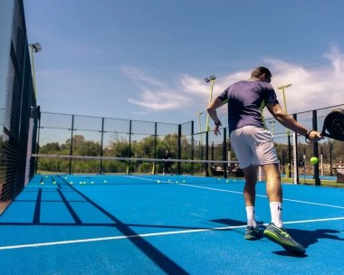 Player hitting a padel shot at Mouratoglou Tennis Center Cala di Volpe in Costa Smeralda, Sardinia.
