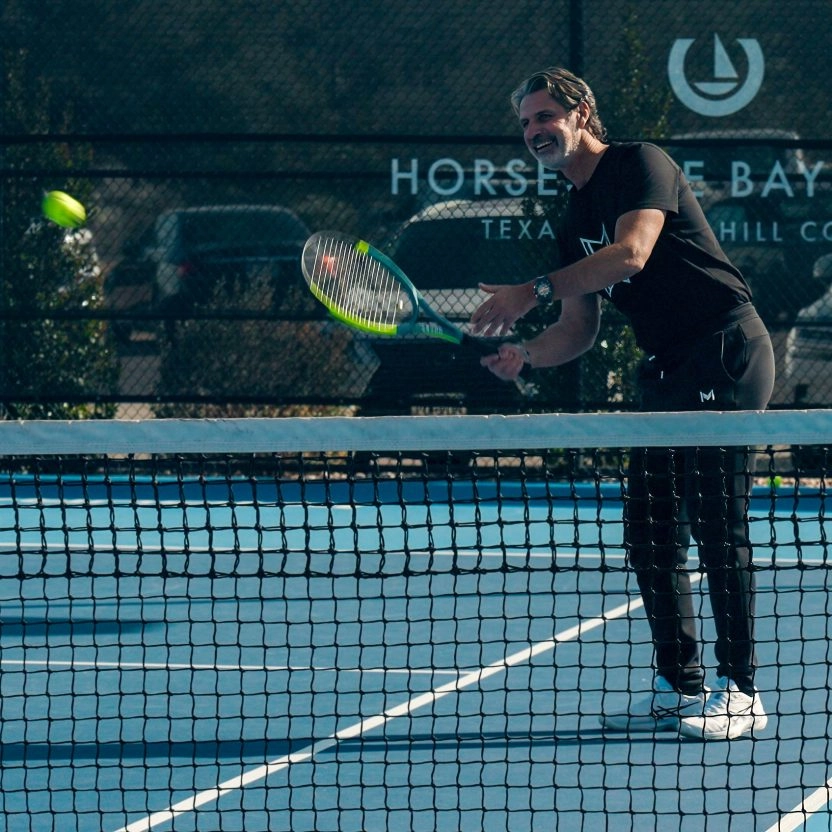 Patrick Mouratoglou hitting a volley at Mouratoglou Tennis Center Horseshoe Bay.