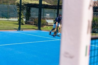Padel player returning a shot at Mouratoglou Tennis Center Cala di Volpe.