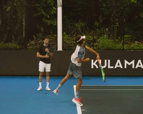 Coach giving a private tennis lesson on a hard tennis court at Mouratoglou Tennis Center Bali.