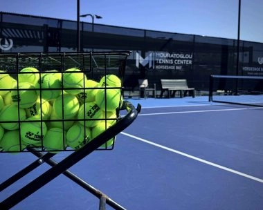 Basket of tennis balls on a court at Mouratoglou Tennis Center Horseshoe Bay.