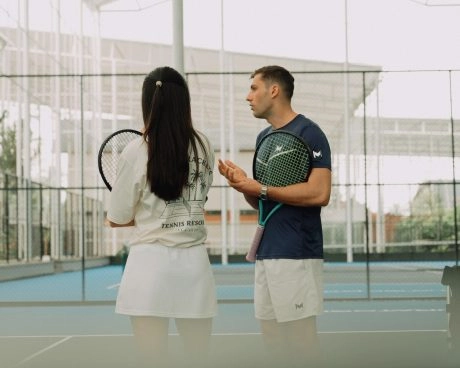 Tennis coach giving advice to a player during a training session at Mouratoglou Tennis Center Bali.