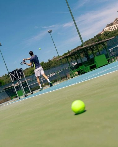 Tennis player practicing during a coaching session at Mouratoglou Tennis Center Cala di Volpe in Costa Smeralda, Sardinia.