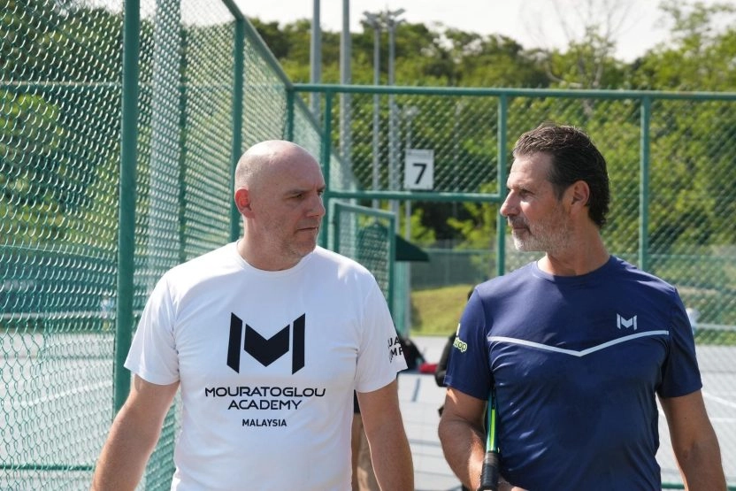 Patrick Mouratoglou walking with a coach at Mouratoglou Academy Malaysia on the campus of Epsom College in Malaysia.