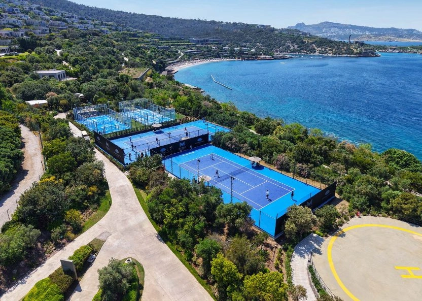 Aerial view of Mouratoglou Tennis Center Bodrum with outdoor tennis and padel courts overlooking the sea at Mandarin Oriental Bodrum.