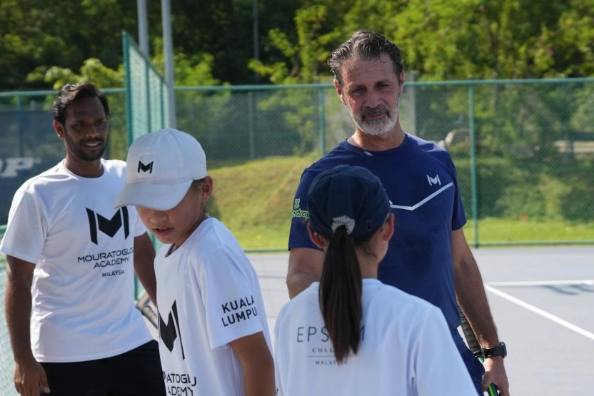 Patrick Mouratoglou coaching students on a tennis court at Mouratoglou Academy Malaysia on the campus of Epsom College in Malaysia.