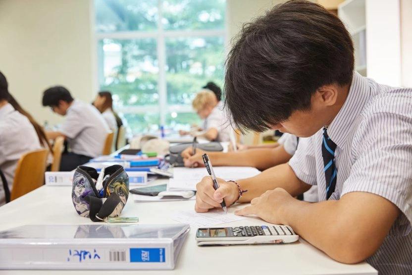 Student writing in a classroom at Mouratoglou Academy Malaysia on the campus of Epsom College in Malaysia.