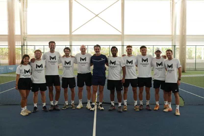 Patrick Mouratoglou posing with the coaching team on an indoor tennis court at Mouratoglou Academy Malaysia on the campus of Epsom College in Malaysia.