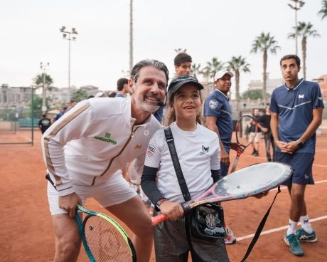 Patrick Mouratoglou posing with a young tennis player on a clay court at Mouratoglou Tennis Center Palm Hills Cairo in Egypt.