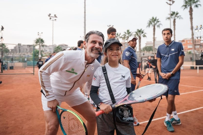 Patrick Mouratoglou posing with a young tennis player on a clay court at Mouratoglou Tennis Center Palm Hills Cairo in Egypt.