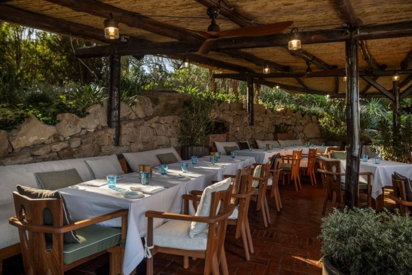 Elegant outdoor restaurant terrace at Hotel Cala di Volpe featuring Mediterranean-inspired dining in a natural setting.
