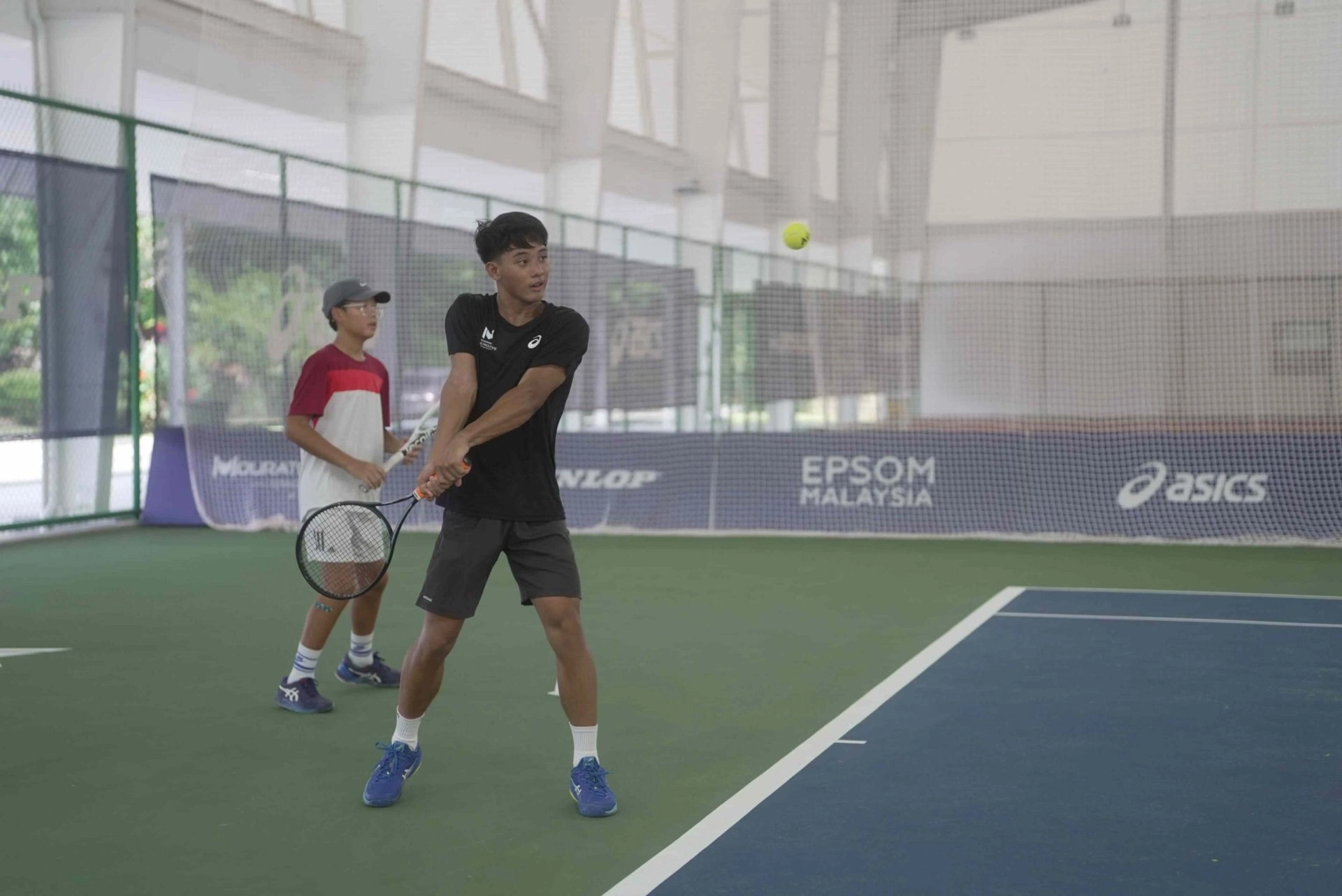 Junior tennis players practicing groundstrokes during a training session at Mouratoglou Academy Malaysia Kuala Lumpur.