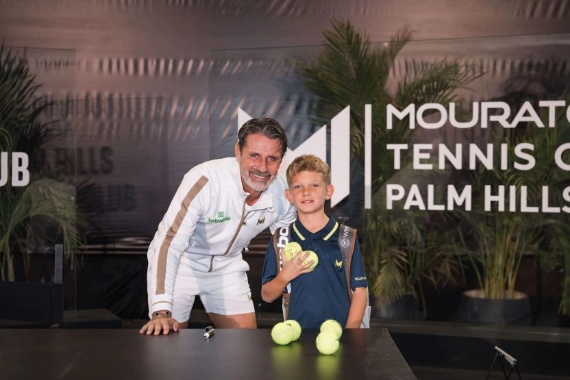 Patrick Mouratoglou posing with a young boy holding signed tennis balls at Mouratoglou Tennis Center Palm Hills, Egypt