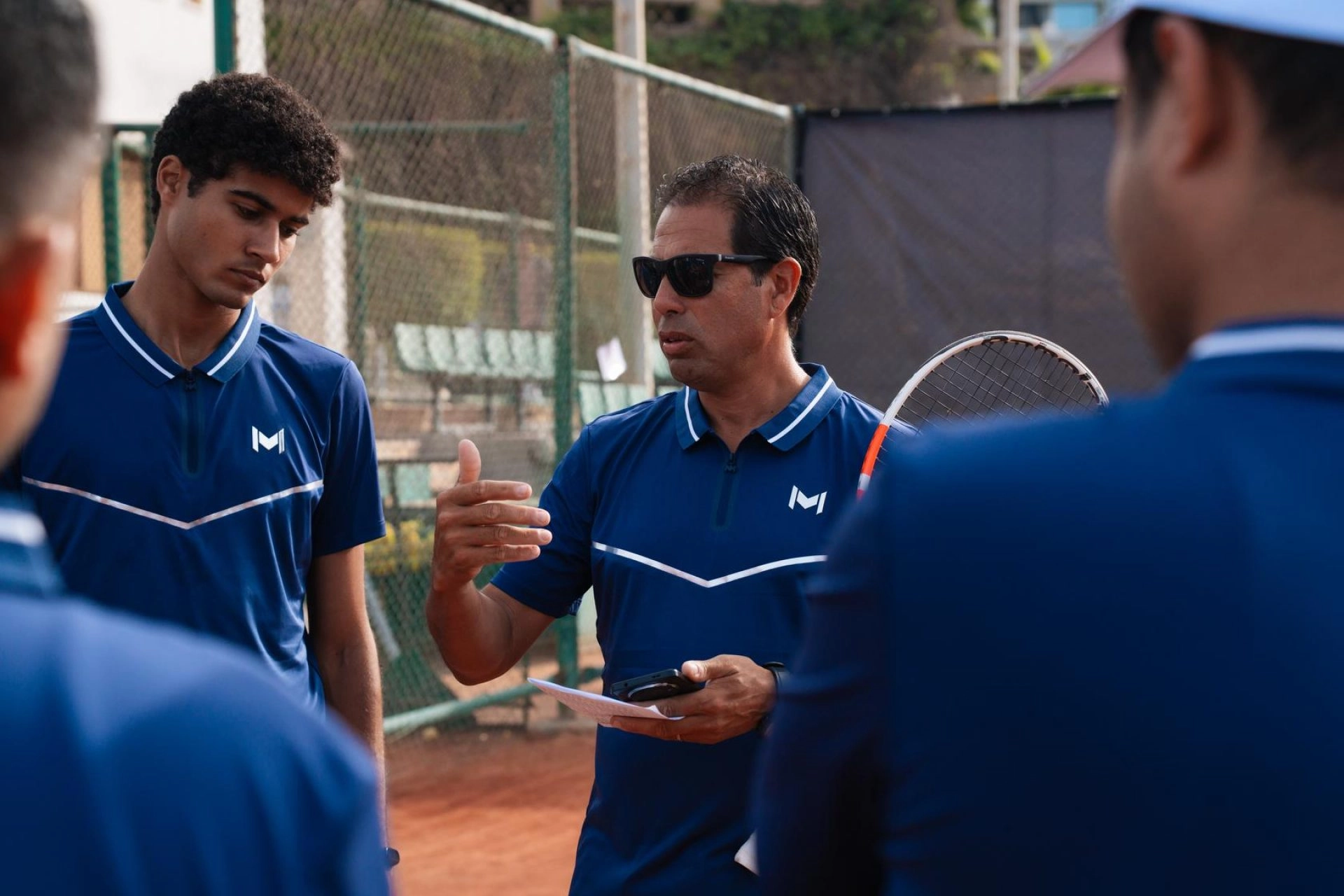 Tennis coach giving instructions to players during a training session at Mouratoglou Tennis Center Palm Hills Cairo in Egypt.