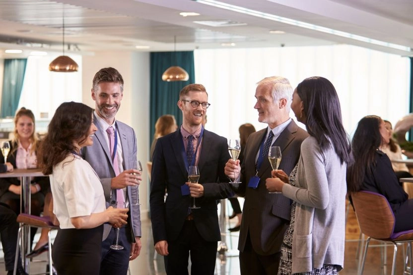 Professionals networking and socializing during a corporate event organized by Mouratoglou Tennis Center.