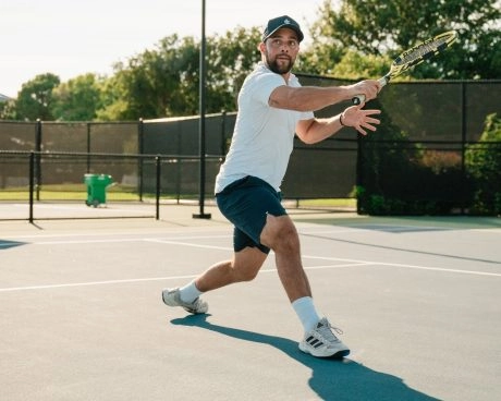 Tennis player hitting a forehand on an outdoor court at Mouratoglou Tennis Center Odessa Midland, located within La Estancia.