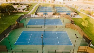 Aerial view of outdoor tennis courts at Mouratoglou Tennis Center Odessa Midland, with pickleball courts and landscaped country club grounds.