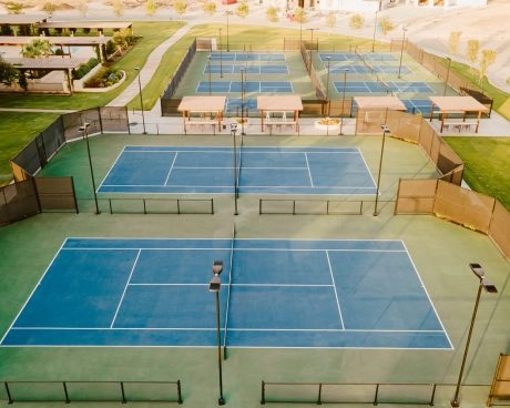 Aerial view of outdoor tennis courts at Mouratoglou Tennis Center Odessa Midland, with pickleball courts and landscaped country club grounds.