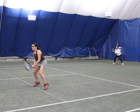 Adult tennis players playing on an indoor court at Mouratoglou Tennis Center Westchester.