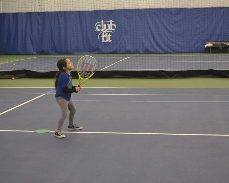 Young tennis player holding a racket on an indoor court at Mouratoglou Tennis Center New York.
