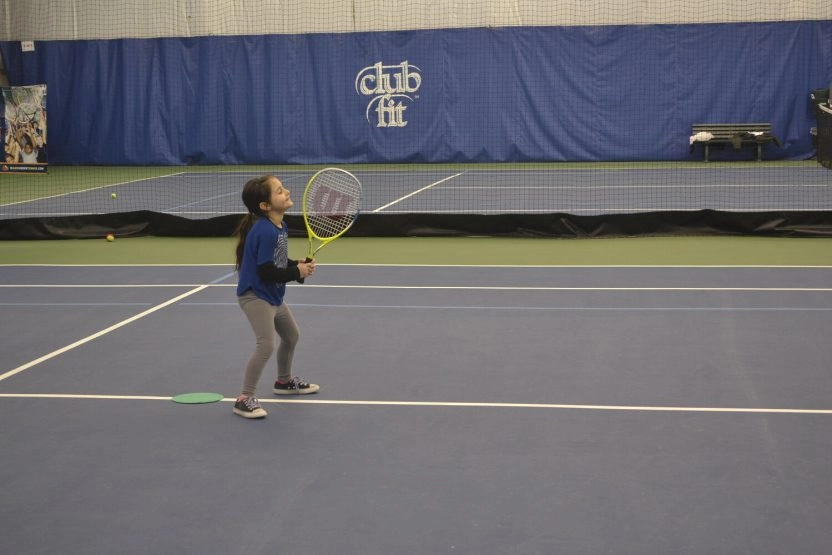 Young tennis player holding a racket on an indoor court at Mouratoglou Tennis Center New York.