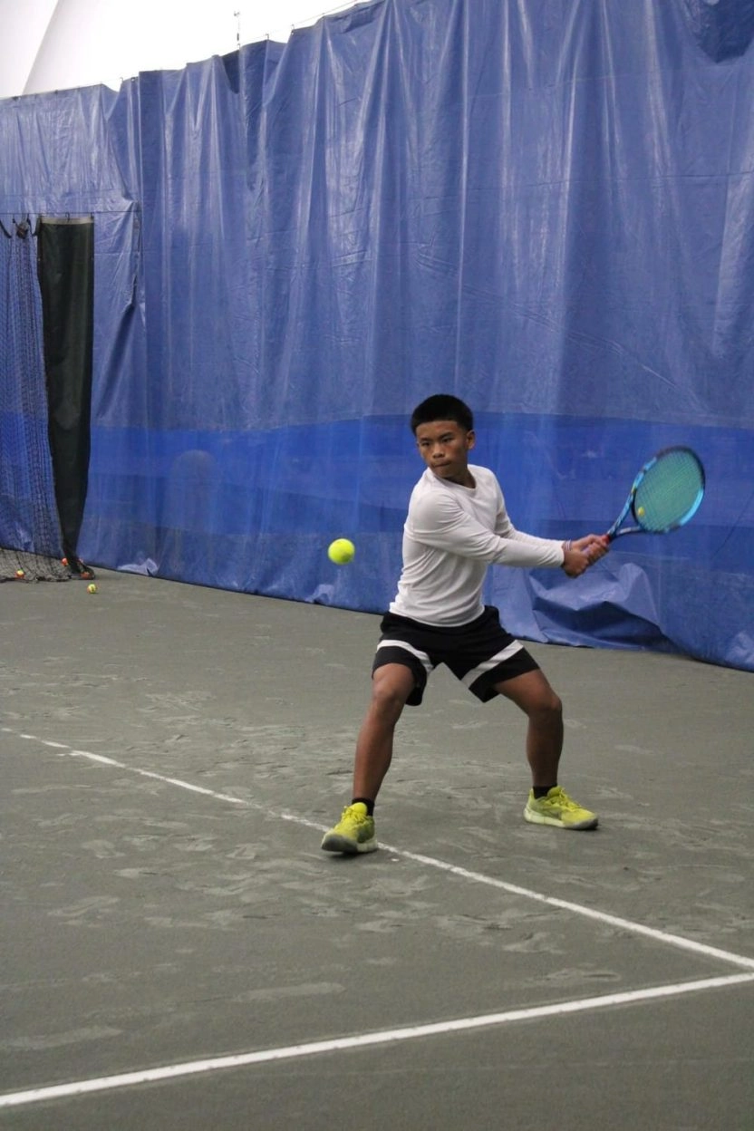 Young tennis player preparing a backhand on an indoor court at Mouratoglou Tennis Center Westchester.