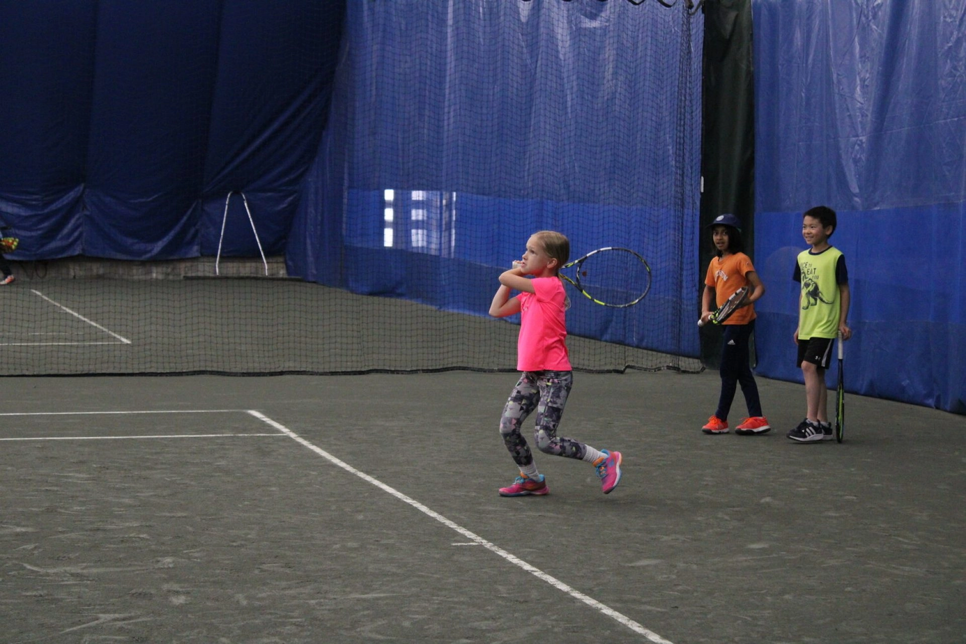 Young tennis players practicing on an indoor court at Mouratoglou Tennis Center Westchester.