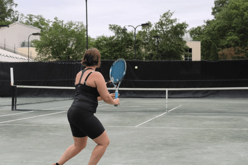 Adult tennis player preparing for a shot on an outdoor court at Mouratoglou Tennis Center Westchester.